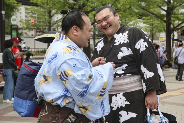 Two sumo wrestlers joke at an event in Tokyo, Tokyo, Ryogoku, Japan