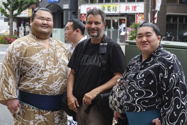 Two sumo wrestlers with a tourist in Ryogoku, Tokyo, Ryogoku, Japan
