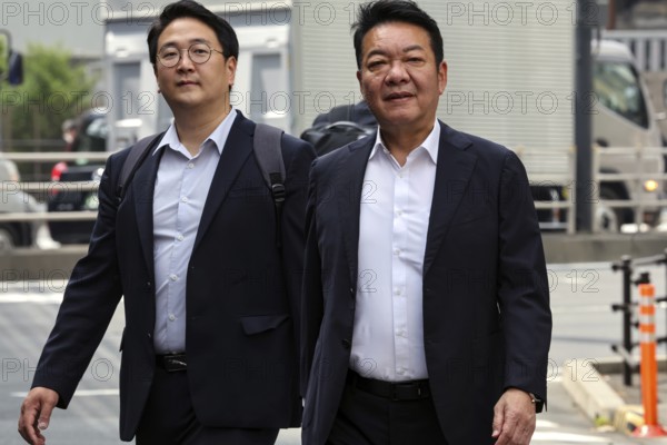 Two businessmen wearing suits on a busy street in Tokyo, Tokyo, Japan