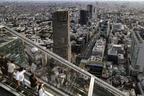 People ride down an escalator in Shibuya Sky with a view of Tokyo, Tokyo, Shibuya, Japan