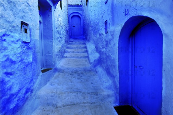 Narrow, blue alleyway section of the medina of Chefchaouen with weathered stairs, Chefchaouen, Tanger-Tetouan, Morocco