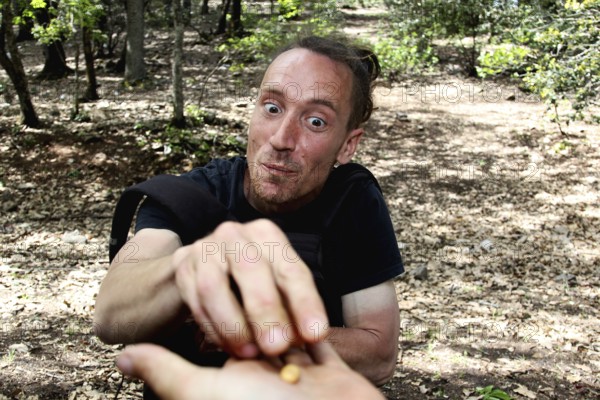 Man feeding with a hand smile in the forest, Azrou, Forèt des Cèdres, Morocco