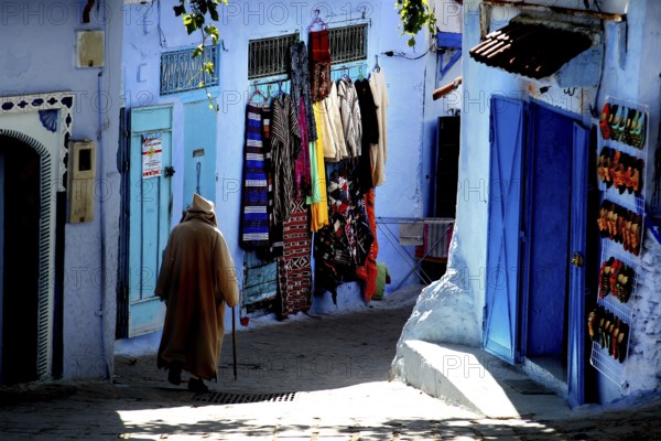 Winding alleys of the Medina with blue walls and colorful clothes, Chefchaouen, Morocco