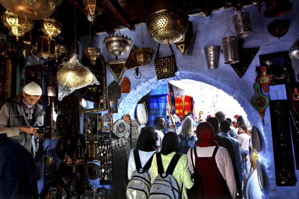 Bustling souk in the medina of Chefchaouen surrounded by blue walls and lights, Chefchaouen, Morocco