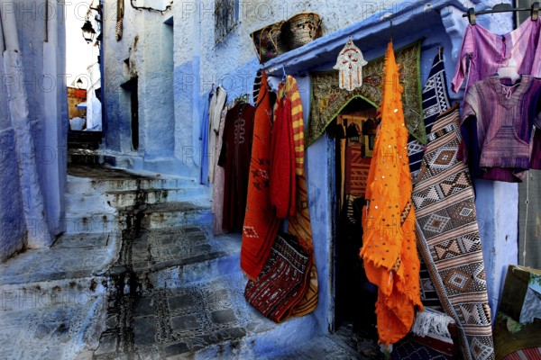 Picturesque blue road in the medina of Chefchaouen with colorful textiles, Chefchaouen, zero, Morocco