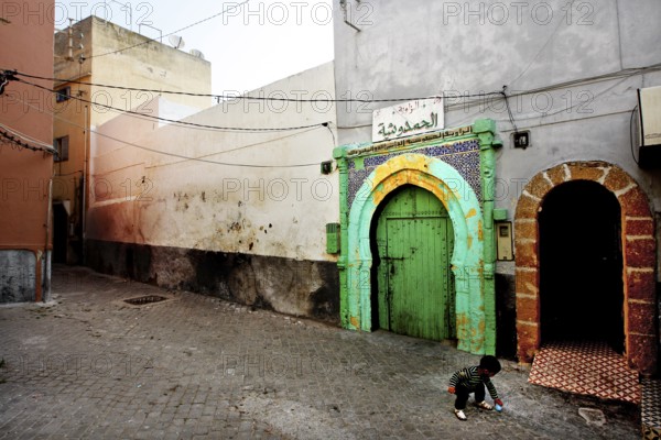 A quiet alley with colorful gates and historic buildings in an abandoned atmosphere, El Jadida, Cité Portugaise, Morocco