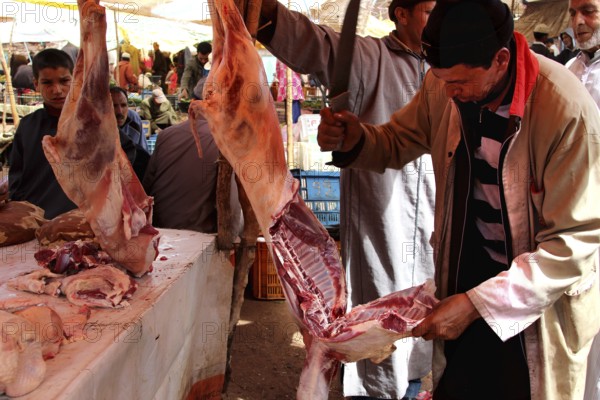 Butchers at a market in Achaouikh processing meat in a lively atmosphere, zero