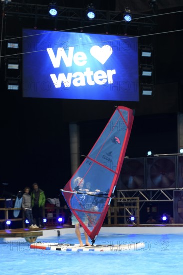 Press photo of wind surfer Windsurfer in the large XXL pool in Hall 17 of Messe Boot Düsseldorf, in the background the motto of Messe boot We Love Water, Messe Boot, Düsseldorf, North Rhine-Westphalia, Germany
