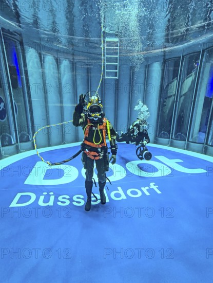 Press photo Helmet diver with modern equipment in the background Recreational diver with small underwater scooter in the diving tower with lettering boot Düsseldorf below from Messe Boot Düsseldorf, Düsseldorf, North Rhine-Westphalia, Germany