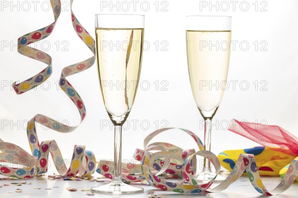 Two champagne glasses filled with colorful streamers, carnival