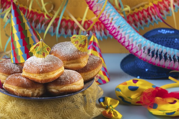 A plate of donuts decorated with party hats and colorful carnival accessories
