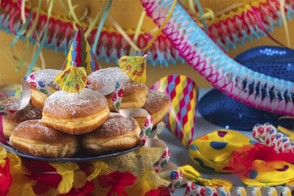 A plate of donuts surrounded by colorful party hats, streamers and garlands, carnival