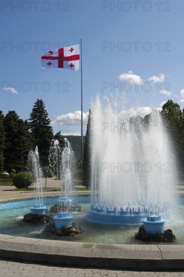 Dynamic fountain in the park with a flag in the background, Georgian flag, Stalin Park, Gori, Inner Kartli region, Georgia