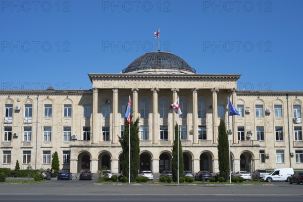 View of classic building with dome and flags surrounded by cypresses, City Hall, Gori, Inner Kartli region, Georgia