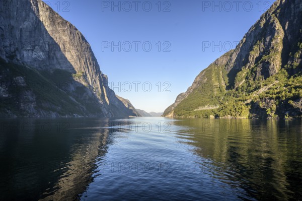 Tranquil Lysefjord surrounded by high mountains whose reflections are visible in the water