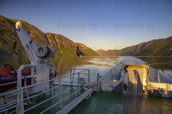Ferry trip on Lysefjord at sunrise with mountains and waves in the background, Lysefjord, Rogaland, Norway