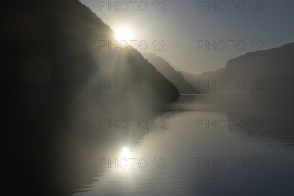 Foggy morning atmosphere over the quiet Lysefjord at sunrise between mountains