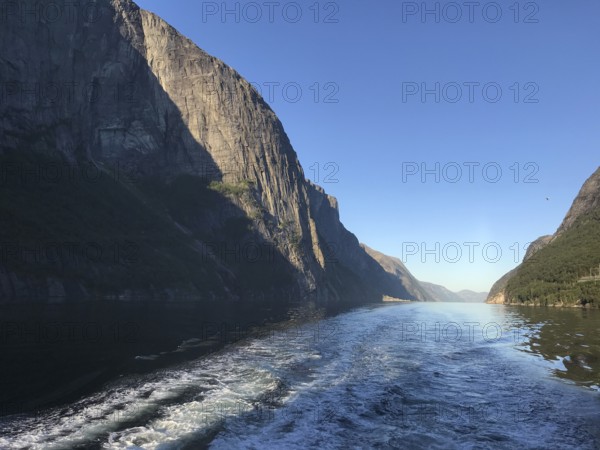 Lysebotn, Rogaland Municipality, Norway, view of the trail of a boat in the quiet Lysefjord between high mountains