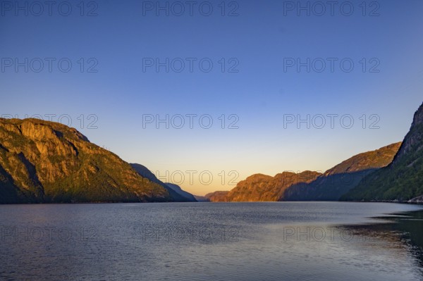 View of Lysefjord and illuminated mountains in the warm light of dusk, Lysefjord, Rogaland, Norway