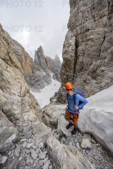 Mountaineers on the Bocca d'Ambiez, Via Ferrata dell'Ideale via Ferrata dell'Ideale, spectacular mountain landscape with steep rock faces, remains of the Vedretta d'Ambiez glacier in the back, Brenta Mountains, Brenta-Adamello Nature Park, Trentino, Italy
