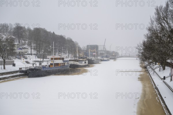 Ships moored on the banks of the frozen Aurajoki River, wintery Turku or Swedish Åbo, Varsinais-Suomi, Finland