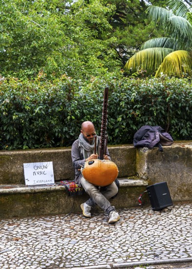 Musician sitting on the side of the N375 road in Sintra, Lisbon, Portugal
