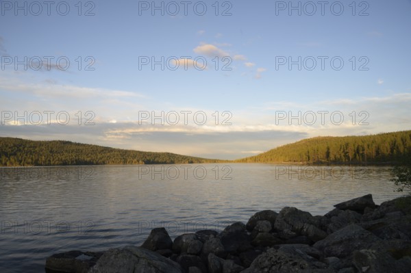 Lake Gutulsjön at dusk, still water under soft evening sky, Gutulia National Park, Engerdal, Innlandet, Norway