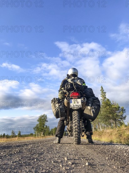 Idre, Dalarnas län, Sweden, BMW G 650 GS Sertao enduro motorcyclist posing on a gravel road under a blue sky