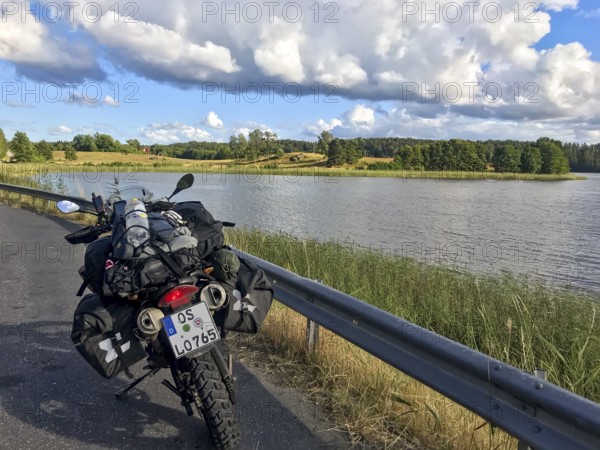 Sparreholm, Södermanlands län, Sweden, BMW G 650 GS Sertao Enduro motorcycle trip along a lake under cloudy sky in idyllic nature