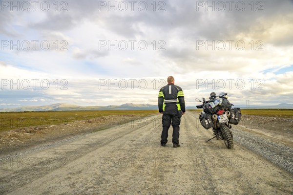 Falkvålen, Bruksvallarna, Jämtland, Sweden, rear view of a rider with a BMW G 650 GS Sertao enduro motorcycle on a long straight road under a wide sky