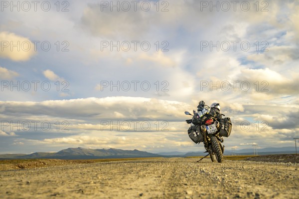 Falkvålen, Bruksvallarna, Jämtland, Sweden, BMW G 650 GS Sertao enduro motorcycle on gravel road against mountainous backdrop under dramatic skies, endless adventure