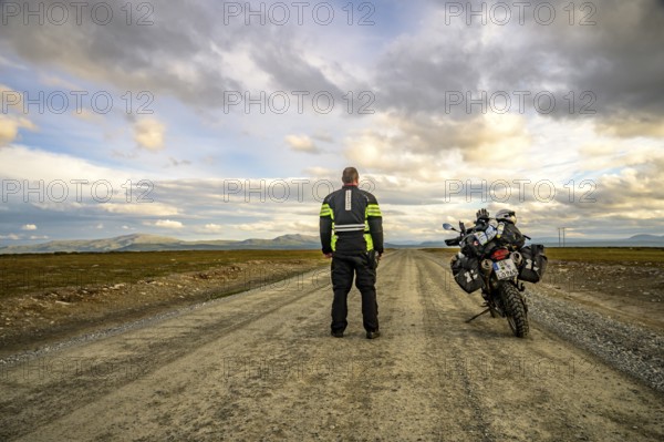 Falkvålen, Bruksvallarna, Jämtland, Sweden, BMW G 650 GS Sertao Enduro motorcyclist standing on a secluded country road, ready for adventure under cloudy skies