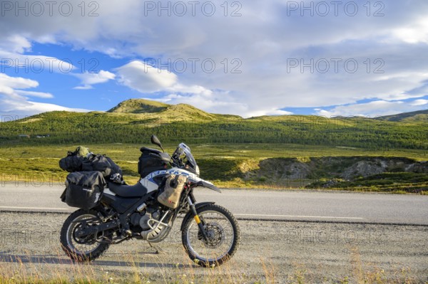Dalholen, Innlandet, Norway, BMW G 650 GS Sertao enduro motorcycle along a road through green hills and wide skies on a journey