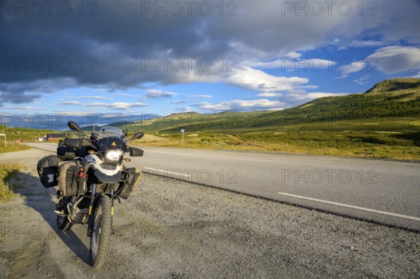 Dalholen, Innlandet, Norway, BMW G 650 GS Sertao enduro motorcycle along a road in an open landscape with sunny sky