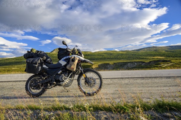 Dalholen, Innlandet, Norway, BMW G 650 GS Sertao enduro motorcycle on a quiet path in a wide hilly landscape under a blue sky