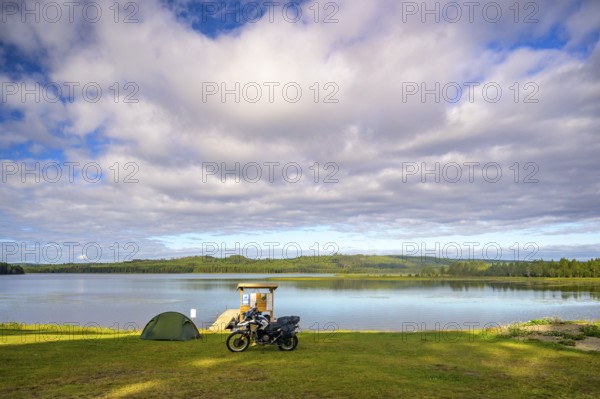 Rörström, Dorotea, Västerbotten, Sweden, picturesque seascape with tent and BMW G 650 GS Sertao enduro motorcycle on the shore under a dramatic sky