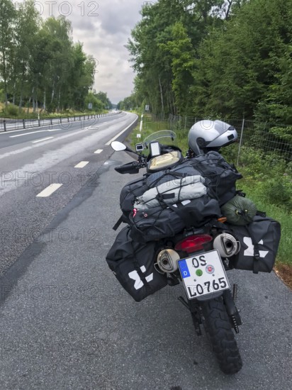 Broby, Skåne län, Sweden, BMW G 650 GS Sertao enduro motorcycle on a road with bags packed for a trip surrounded by trees
