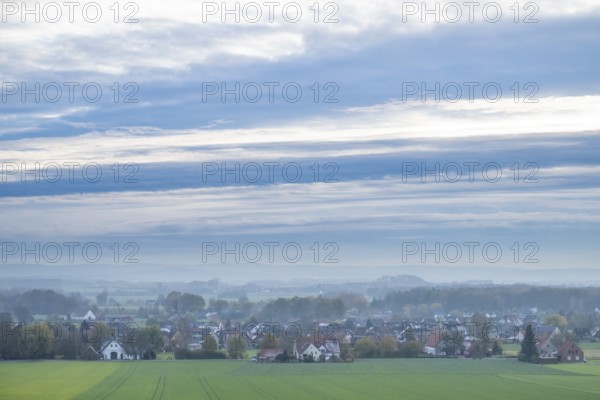 Extensive landscape with a village, fields, houses and cloudy sky in the morning, Föckinghausen-Westerhausen, Melle, Osnabrücker Land, Lower Saxony, Germany, quiet village landscape with wide fields and an overcast sky in autumn colors