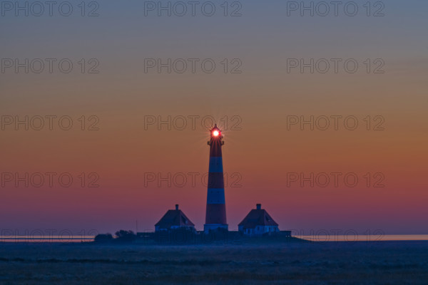Silhouette of a lighthouse at sunset by the sea, calm and peaceful atmosphere