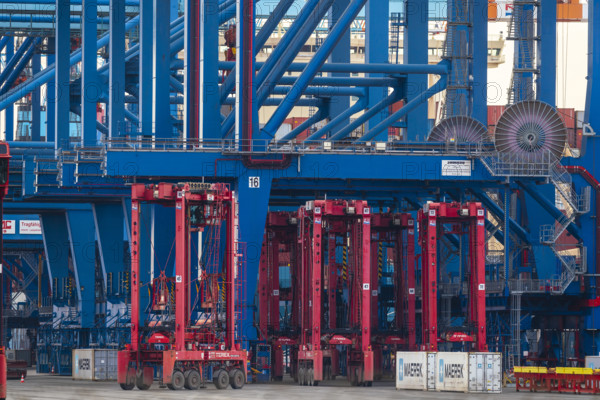 Industrial complex with large blue and red container cranes in action