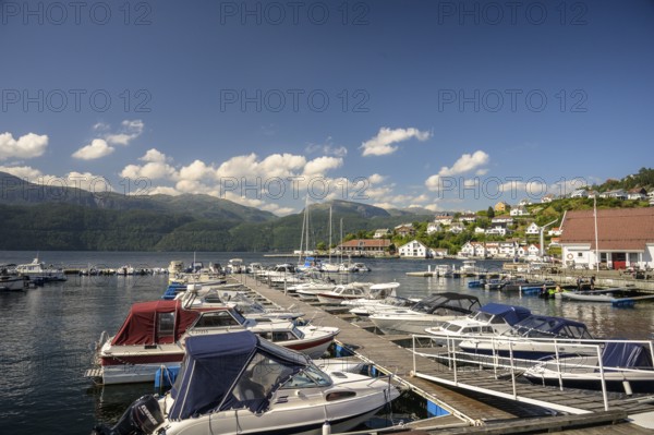 Sand, Rogaland Municipality, Norway, boats in harbor on a sunny day with mountains in the background