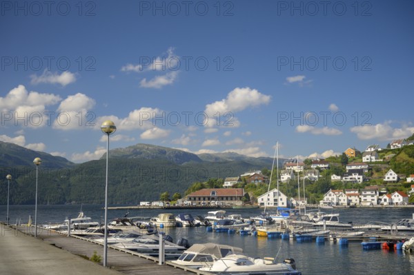 Sand, Rogaland municipality, Norway, harbour full of boats in front of a city with mountains in the background