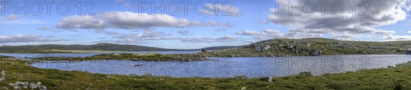 Haugastøl, Viken, Norway, vast landscape with a lake under a cloudy blue sky in Hardangervidda