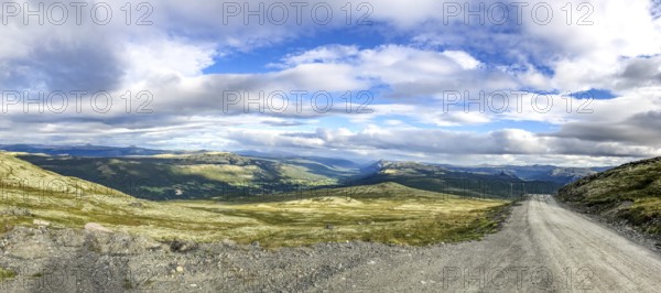 Tylldal, Innlandet, Norway, panoramic view of mountains and a dirt road under cloudy sky, Norway's highest freely accessible road