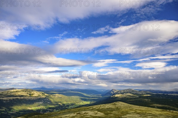Tylldal, Innlandet, Norway, vast landscape with mountains and dramatic sky surrounded by greenery