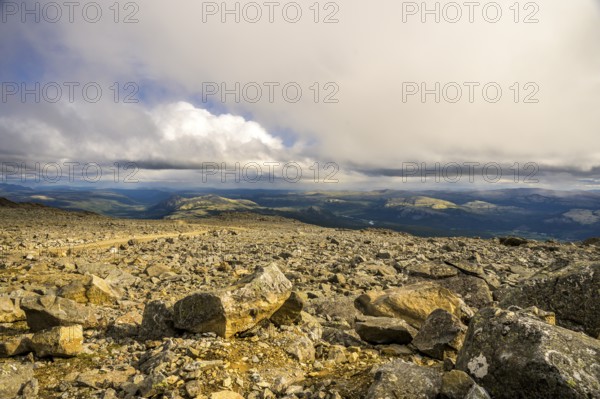 Alvdal, Innlandet, Norway, far-reaching view over a rocky landscape under a dramatic sky, road to Tronfellet with an altitude difference of 1161 m the highest navigable road in Norway