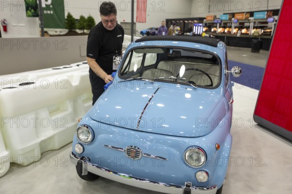 Detroit, Michigan USA - 15 January 2026 - A worker polishes a 1962 Fiat 500 at the Detroit Auto Show