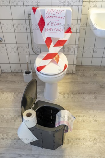 Symbolic picture blackout, extensive, prolonged power failure, in private environments, without electricity, the water supply also fails, toilet flush no longer works, emergency toilet, mobile toilet, camping toilet as an emergency replacement, disposal in bags