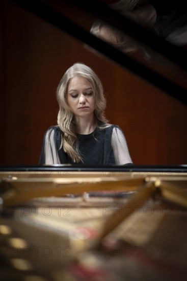 Young woman, pianist, with concentrated facial expression playing on a Steinway & Sons grand piano, Stuttgart, Baden-Württemberg, Germany