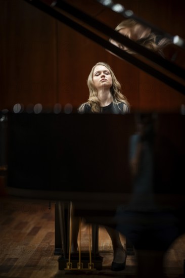 Young woman, pianist, with concentrated facial expression and closed eyes playing on a Steinway & Sons grand piano, Stuttgart, Baden-Württemberg, Germany